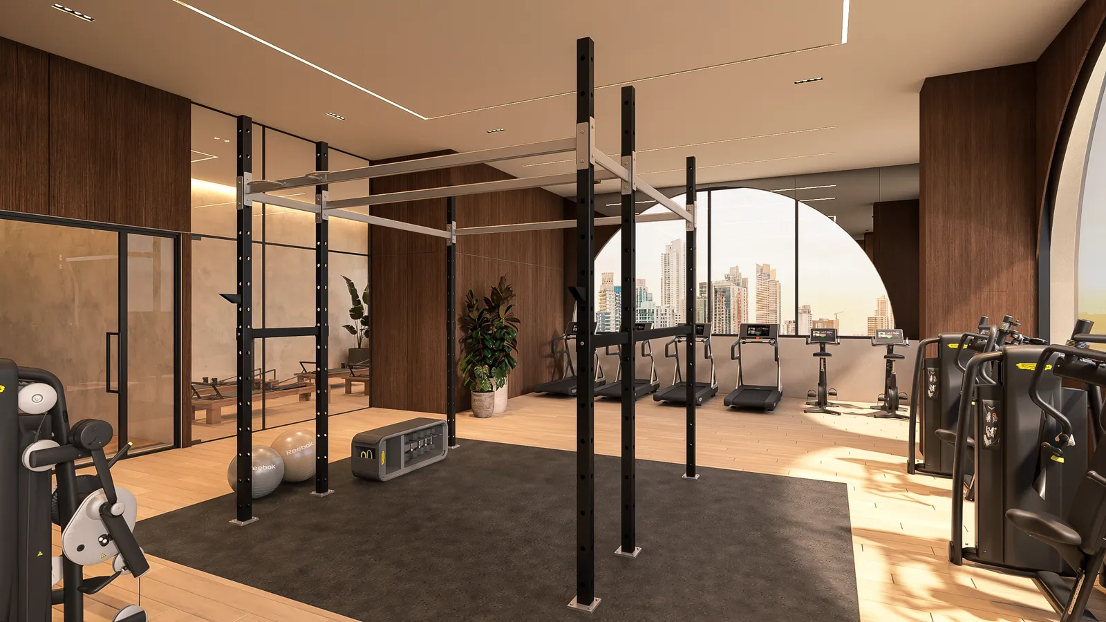Gimnasio equipado con máquinas y vistas a la ciudad.