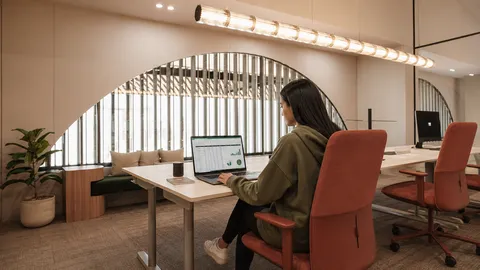 Mujer trabajando en un espacio de coworking luminoso y moderno.